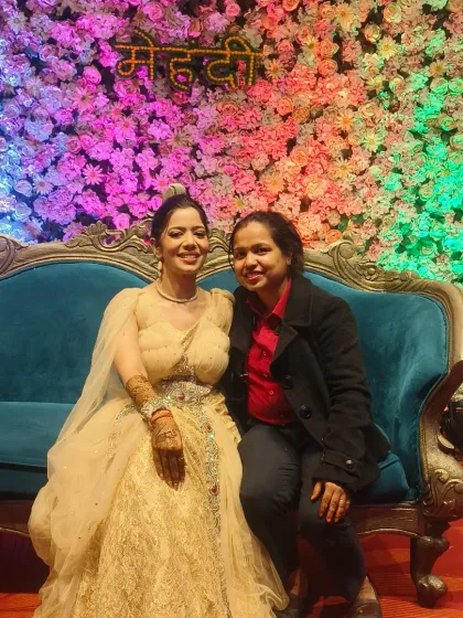 Another picture with a happy bride in front of a beautiful mehandi backdrop.