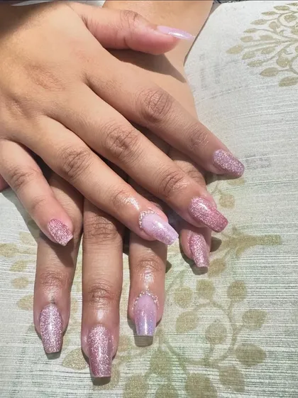 A beautiful set of pink glitter nails with a subtle marble effect.