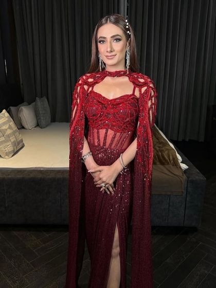 The crimson red gown, a true showstopper that exudes confidence and luxury with its flawless tailoring and intricate design.