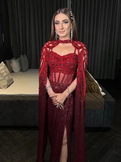 The crimson red gown, a true showstopper that exudes confidence and luxury with its flawless tailoring and intricate design.