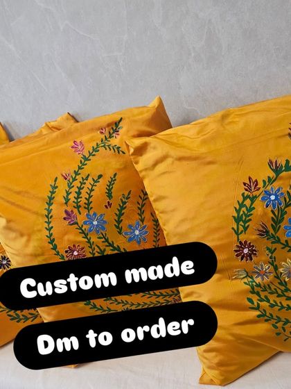 A close-up of the custom-made yellow silk cushion covers with hand-painted floral designs. These are perfect for adding a pop of color and a personal touch to your sofa or bed.