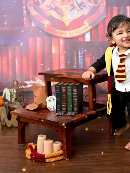 Expecto Patronum! A magical first birthday for a little wizard. This Harry Potter themed photoshoot is complete with a Gryffindor scarf, a wand, and a spellbinding smile, perfect for fans of the wizarding world.
