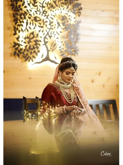 A beautifully lit bridal portrait, with the bride standing by an artistic tree lamp, creating a warm and magical glow.