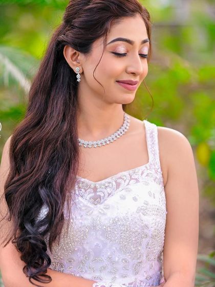 A serene and beautiful bridal portrait. This close-up highlights the delicate beading on the bodice of the white gown and the bride's elegant hair and makeup.