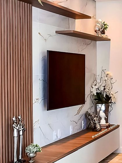 This TV wall design combines vertical wood fluting with a white marble-effect panel. The contrast of textures adds depth and sophistication to the living space, creating a luxurious focal point.