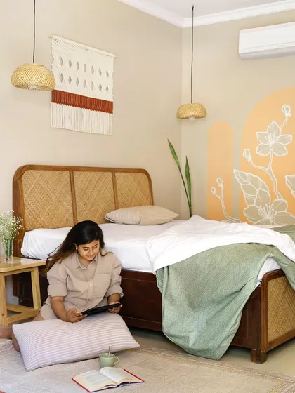The bedroom at Unallome is a sanctuary of calm. Here, our founder Ritika Rakhiani enjoys the serene atmosphere she designed, which features a cane bed, macrame wall hangings, and a soft, earthy color palette.
