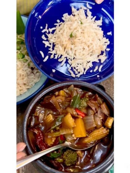 A spoonful of our Sichuan Claypot, showing the rich, dark broth and hearty vegetables. It's an explosion of flavors that you'll relish and remember.