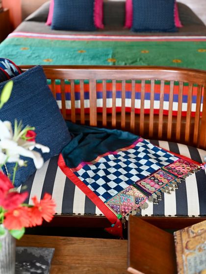 A pure linen throw edged with a border made from vintage Lambani head patches. The combination of the simple linen and the intricate, mirror-work embroidery creates a beautiful textural contrast.