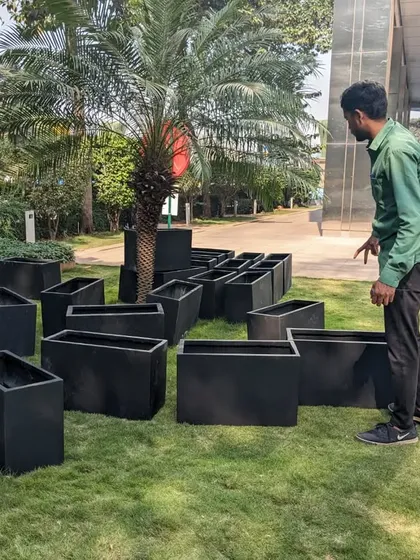Here are the empty, black FRP planters laid out on the grass at the BKC site. This shows the quantity and scale of the planters needed for just one section of this large commercial project.
