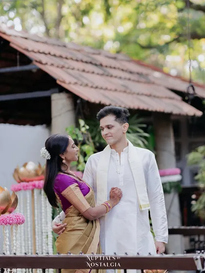 A quiet look shared between a couple, framed by the traditional tiled roof of a pavilion. This showcases the simple, understated elegance of the venue.