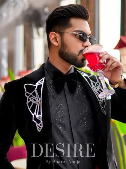 Sipping a drink in the black velvet tuxedo. This is a look designed for evenings of celebration and high style.