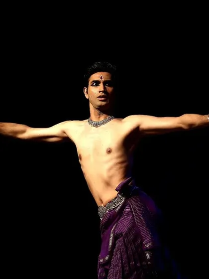 A dynamic pose from a live performance, showcasing the physical control and energy required for a full-length solo recital.