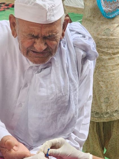 An elderly gentleman getting his blood sugar checked at our medical camp. Regular check-ups are vital for early detection and management of conditions like diabetes.