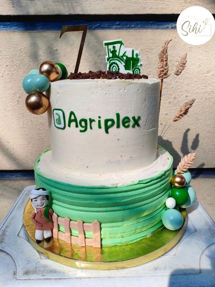 A two-tier cake to celebrate a company milestone for an agriculture business. The design includes a fondant farmer, a tractor, and wheat stalks for a perfectly on-brand celebration.
