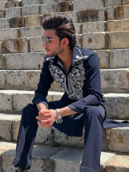 A relaxed shot of the model in the navy blue embroidered kurta.