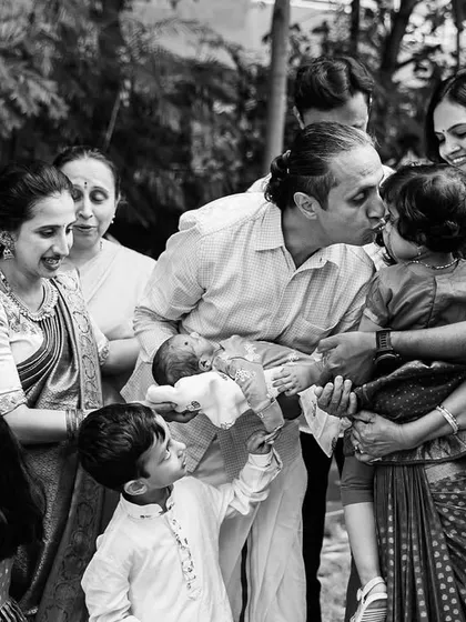 The gentle love of a grandfather for his grandchild, captured in a timeless black and white portrait. These are the quiet, profoundly emotional moments we seek to preserve during family milestone events like naming ceremonies.