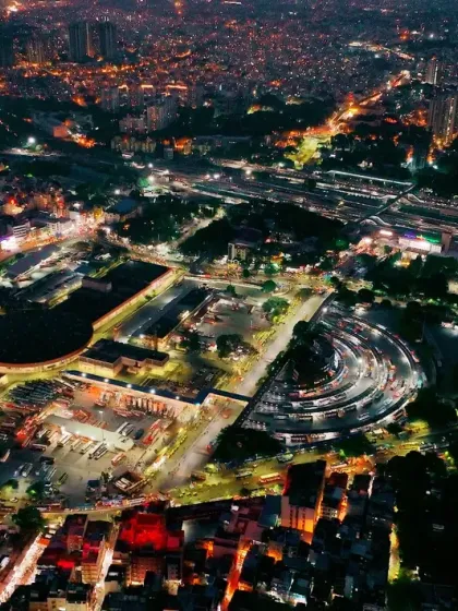 The heart of Bengaluru at night. This aerial shot captures the illuminated Majestic bus and train stations, a central hub of activity.