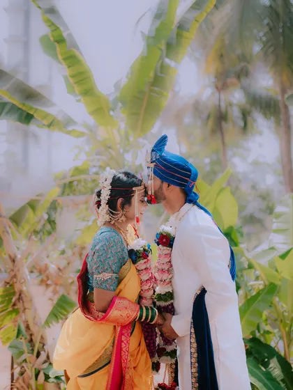 A tender moment as the groom kisses the bride's forehead after the wedding ceremony.