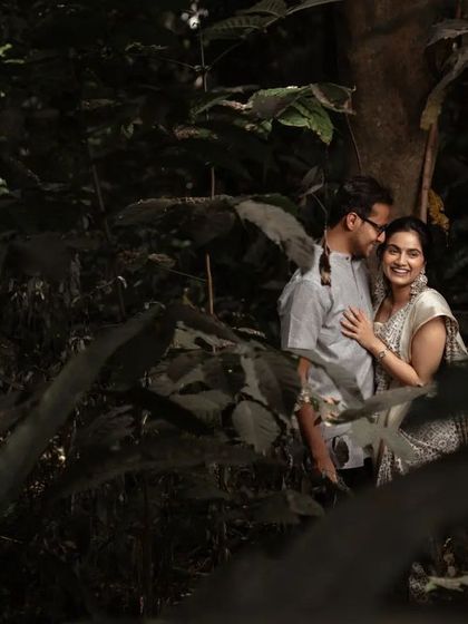 A creative shot of a couple nestled among lush greenery. We love using natural elements to frame our subjects and create a sense of intimacy and seclusion.