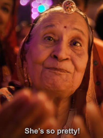 A heartwarming shot of the grandmother from the IPL ad, styled in a traditional saree and borla, looking on with love.
