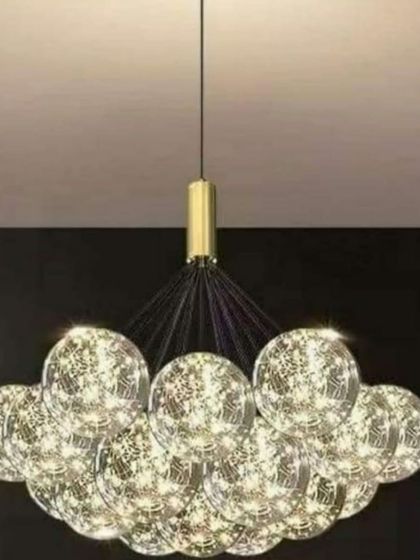 This wire ball pendant light features a cluster of glass globes filled with fairy-like LED lights, creating a magical, starry effect. It's a whimsical and decorative piece that adds a touch of wonder to any room.