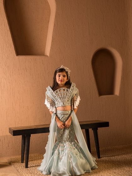 The front view highlights the intricate silver embroidery on the skirt and the dramatic blouse design.