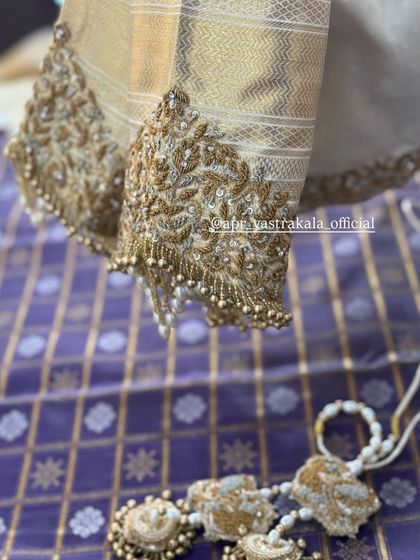 Heavily embroidered sleeves in gold zardosi with pearl tassels.