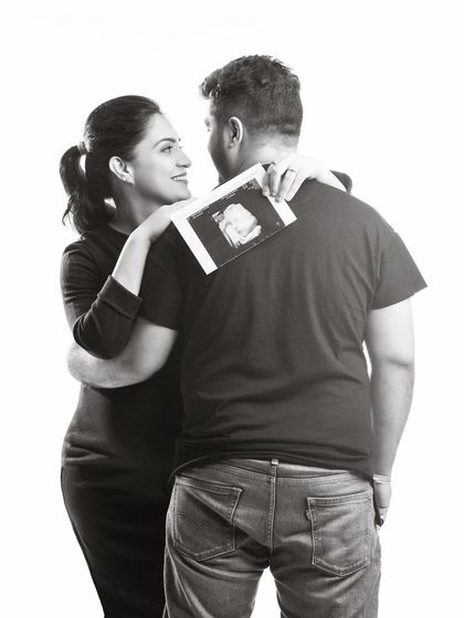 A sweet black and white photo showing the sonogram picture. This creative pose is an intimate way to include the baby's first image in the couple's maternity session.