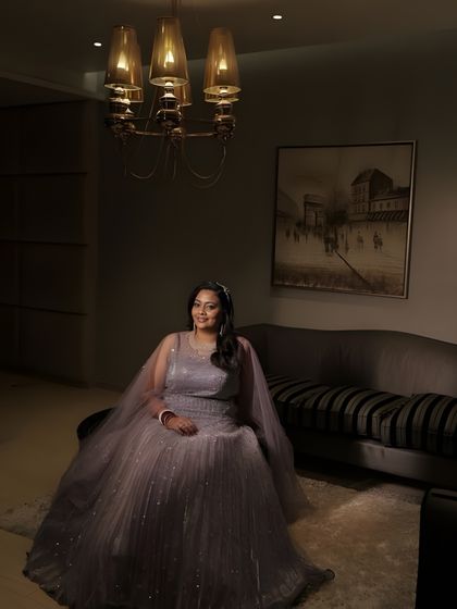 A posed shot in a modern interior. The bride's soft glam makeup and elegant gown create a look of timeless sophistication.