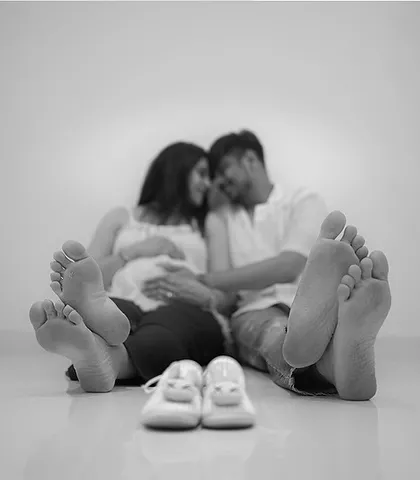 A classic for a reason. This black and white portrait, focusing on the couple's feet alongside a tiny pair of baby shoes, symbolizes the new path they are about to walk together.