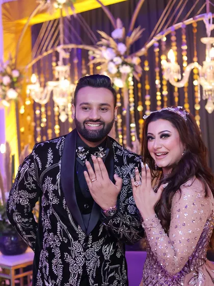 The moment it becomes official. We captured the pure happiness of this couple as they proudly displayed their engagement rings, smiling brightly against a backdrop of elegant chandeliers and floral decor.