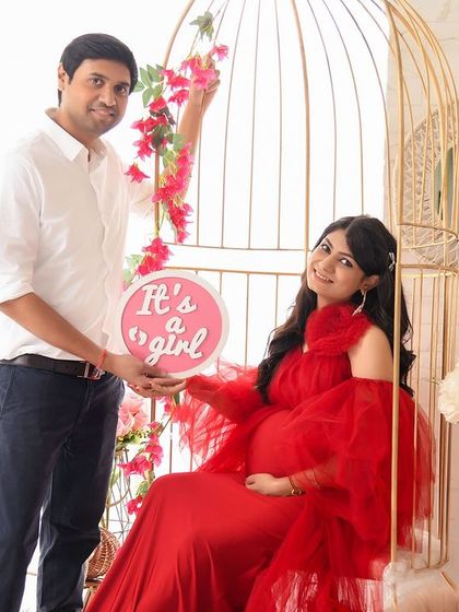 A fun gender reveal photo in our boho birdcage setup. The couple is all smiles as they announce "It's a girl!" with a cute pink sign.