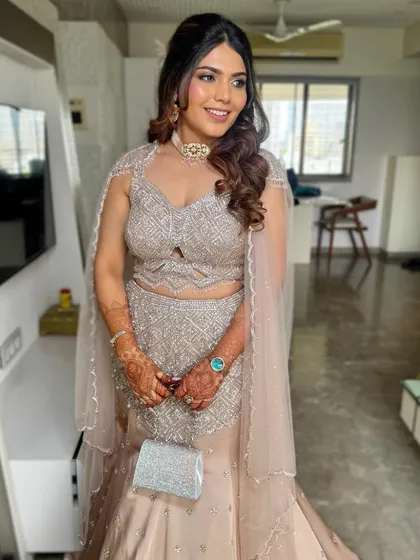 A full view of the client's outfit and hair. The glamorous waves add a touch of Hollywood elegance to her sparkling lehenga.