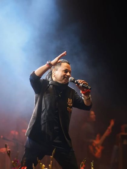 A candid shot of Kailash Kher interacting with the audience. His smile and gesture show the deep connection he builds with his fans during a live show.