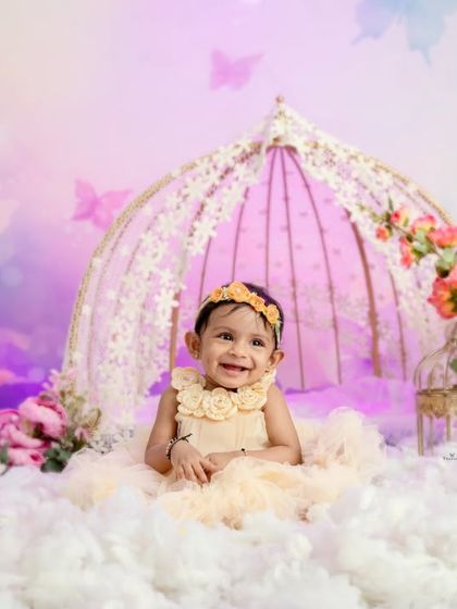 A joyful smile from our little butterfly princess, surrounded by soft clouds and pastel colors in this whimsical setup.