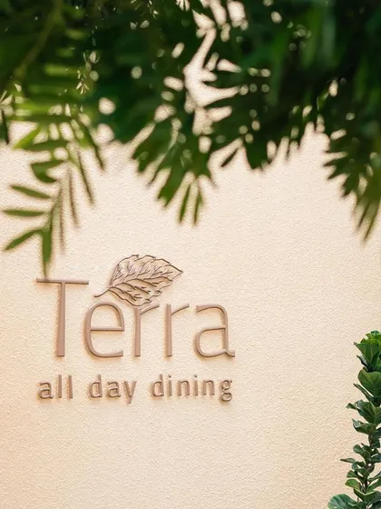 The Terra restaurant signage, framed by lush greenery, marking the location of our celebratory brunches.
