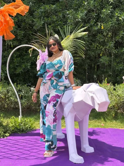 Posing next to a geometric animal statue, one of the many unique decor elements at the wedding carnival.