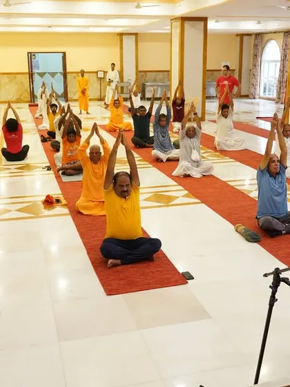 Participants at the ISKCON temple session practicing an upward-stretching asana, embracing the true essence of Yoga in a deeply spiritual setting.
