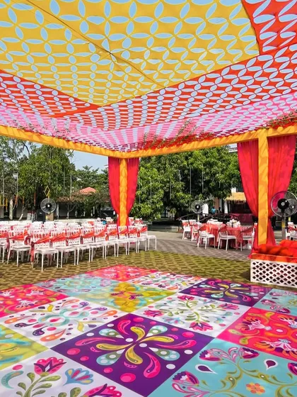 A vibrant and colorful setup with a patterned dance floor and a bright canopy, perfect for a lively Haldi party.