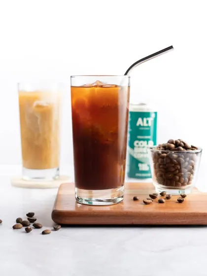 A clean and minimalist shot of iced coffee. The simple composition and bright, airy background give it a modern and refreshing feel, perfect for a cold brew brand.