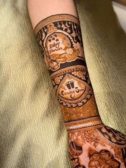 Another angle of the forearm, showing the intricate details of the baby-themed design.