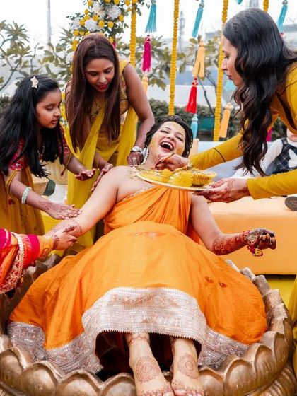 Another shot of the bride's Haldi, capturing the playful and loving atmosphere as her friends and family participate.