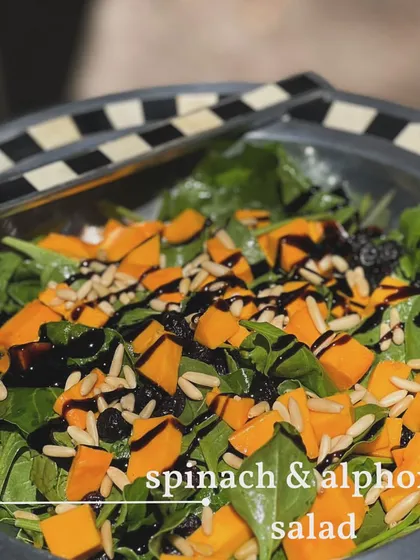 Another view of the vibrant Spinach and Alphonso Salad, ready to be served from a stylish black and white bowl. A healthy and delicious option for any event.