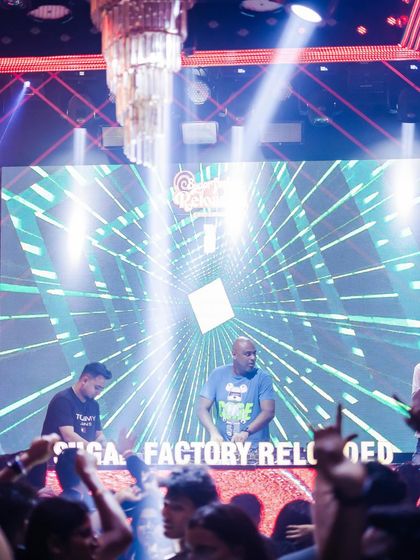 A wide shot of me commanding the stage and the massive LED screen at Sugar Factory.