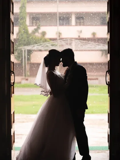 A stunning silhouette of a bride and groom in a doorway. This artistic shot uses light and shadow to create a powerful and romantic image that feels timeless.