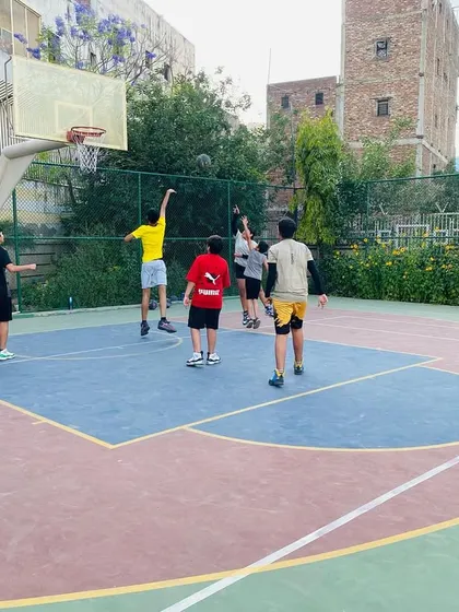A player takes a three-point shot, a skill we develop in our older and more advanced players.