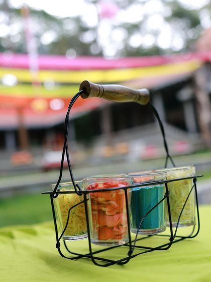 A rustic 'cutting chai' glass holder used as a centerpiece, a quirky and creative detail for a Mehendi ceremony.