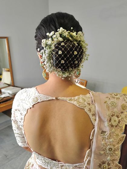 A classic bridal bun covered with a net of baby's breath. This is a unique and elegant way to incorporate flowers into your hairstyle.