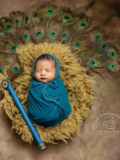 The details make the difference. Here, the focus is on the baby's peaceful expression while being securely wrapped, surrounded by the iconic elements of a Krishna photoshoot.