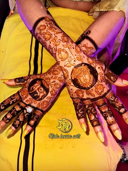 A beautiful back hand design for a client, featuring traditional figures of a goddess and an elephant inside circular frames. The floral patterns around it complete the look.